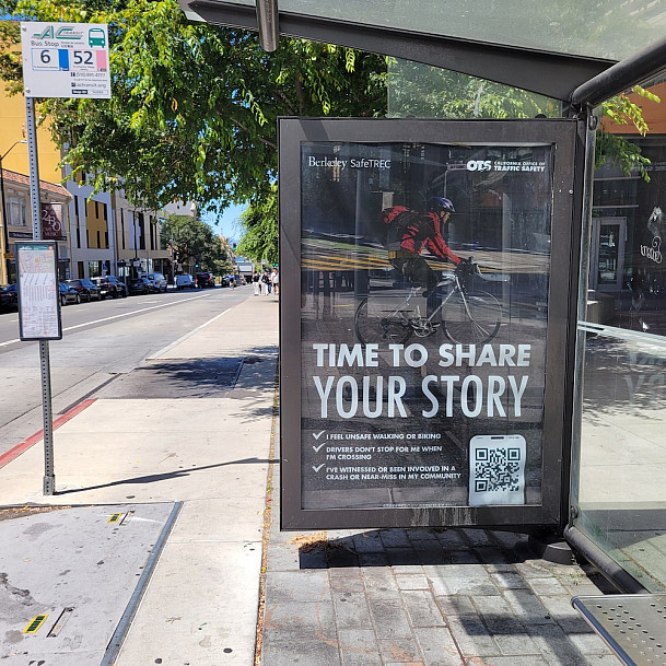 A bus stop poster on Bancroft, near UC Berkeley, shows a bicyclist with the call overlaid Time to Share Your Story